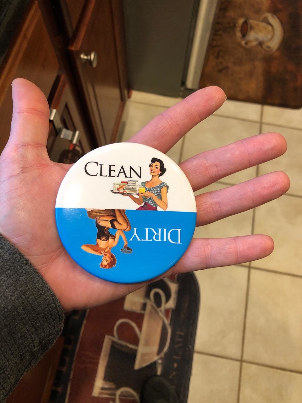 reviewer holding the circle magnet, one half of which says "clean" and shows a smiling housewife, and the other half says "dirty" and features a pinup girl