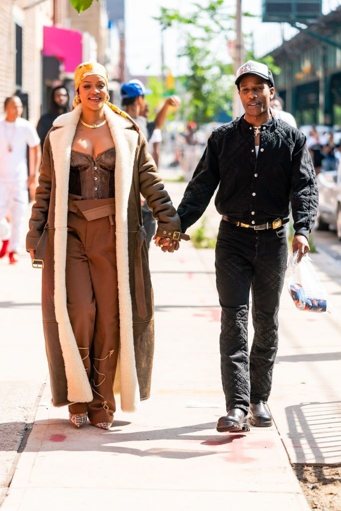 Rihanna is dressed in a long, fuzzy coat and a corset top, and Rocky has a denim shirt tucked into his quilted jeans