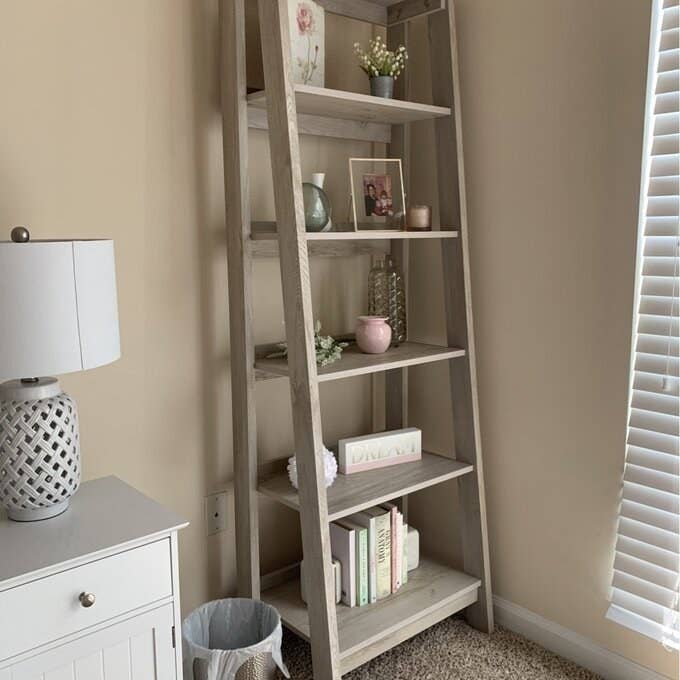 A reviewer&#x27;s image of a ladder bookcase inside a bed room