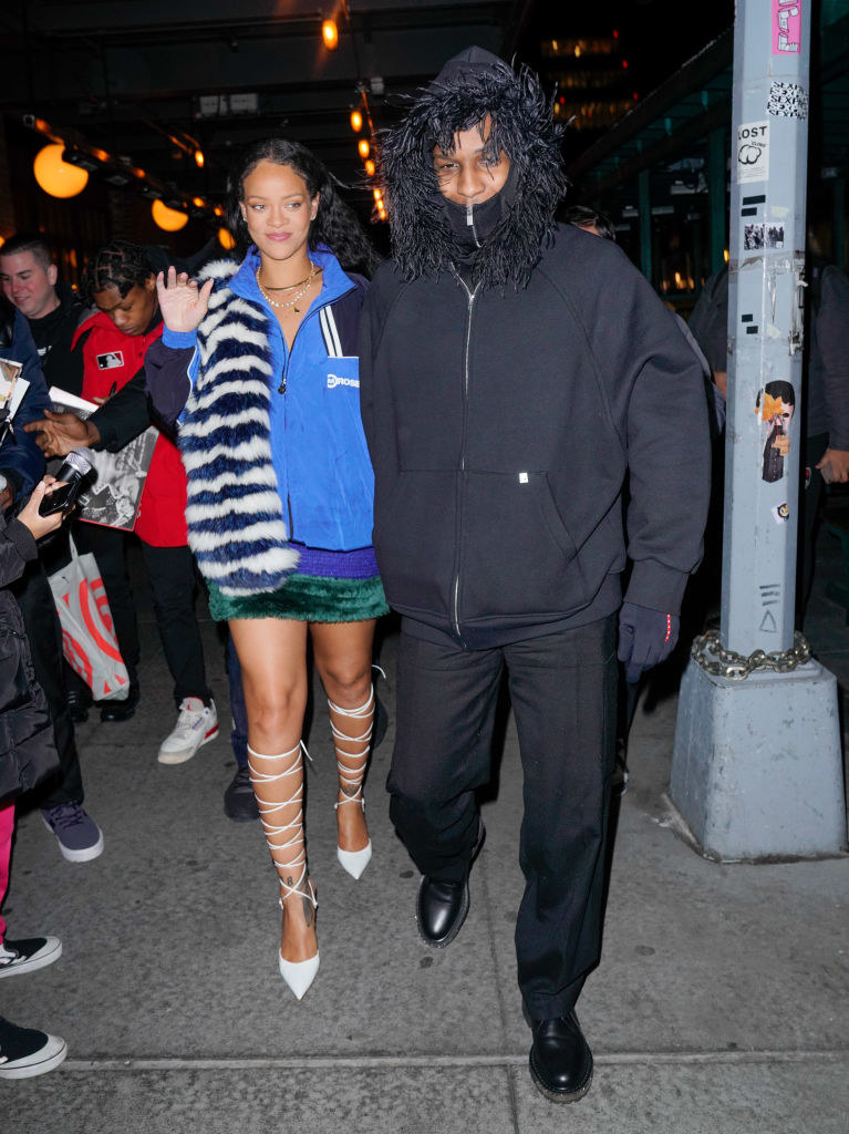 Rihanna wears a furry jacket in bold colors on the other with a short skirt and strappy heels, and Rocky wears a coat with a furry hood and matching pants