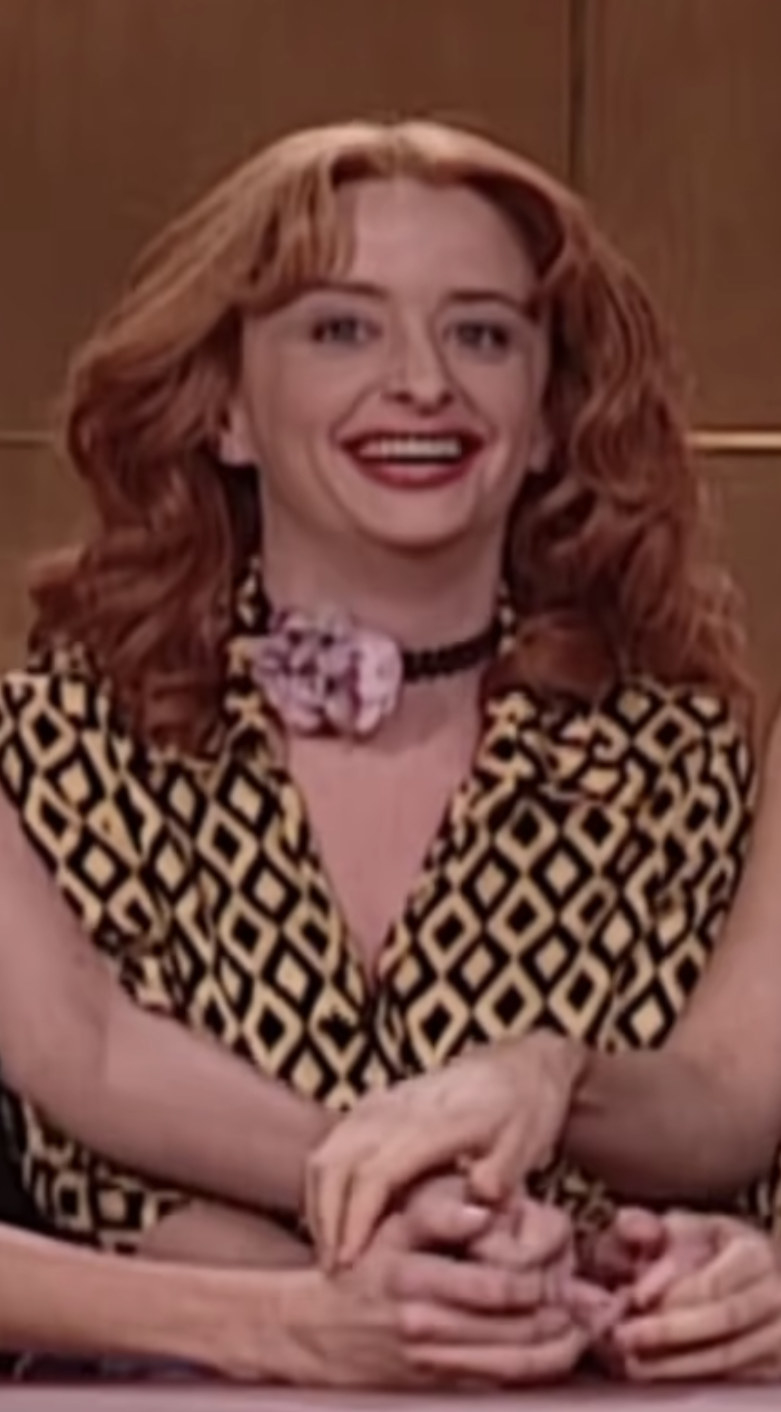 Dratch wearing a red wig and colorful, patterned suit