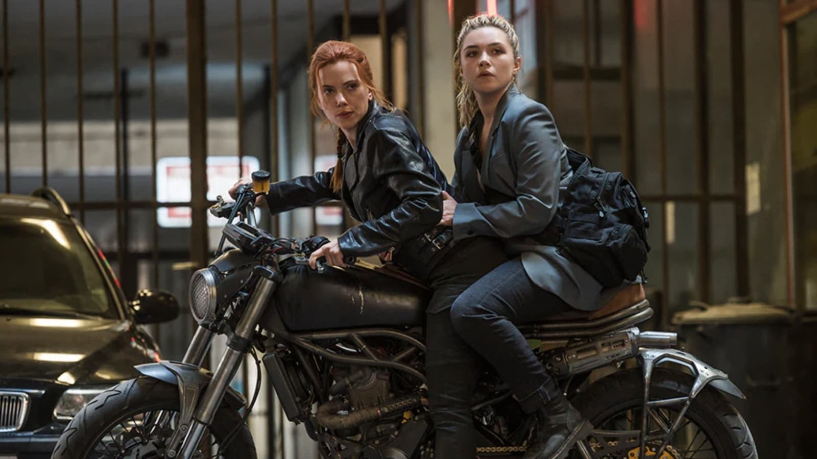 Natasha Romanoff and Yelena Belova sat on a motorbike, looking at something off-screen