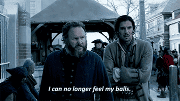 a gif of two characters from Black Sails shivering and saying I can no longer feel my balls