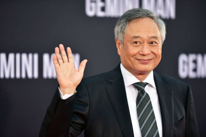 Ang Lee smiling and waving at a movie premiere