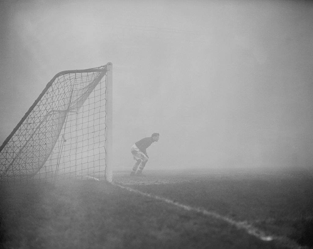 A soccer goalie playing in a dense fog