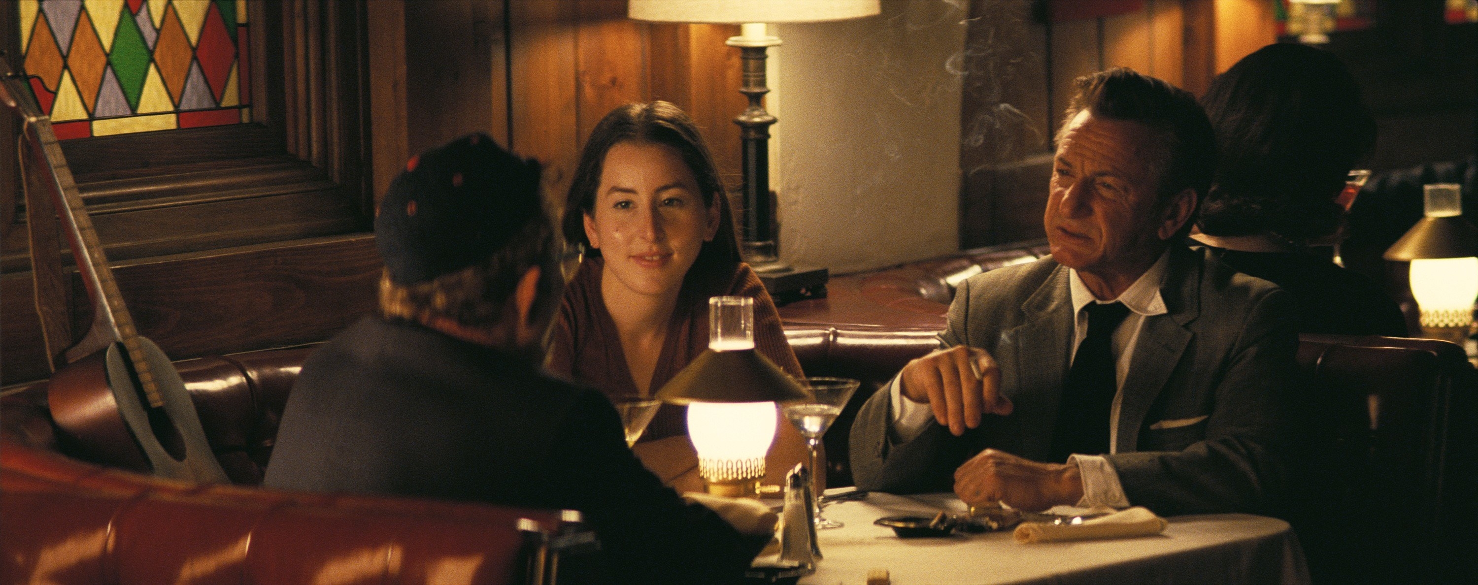 Sean sitting in a restaurant booth in a scene from Licorice Pizza