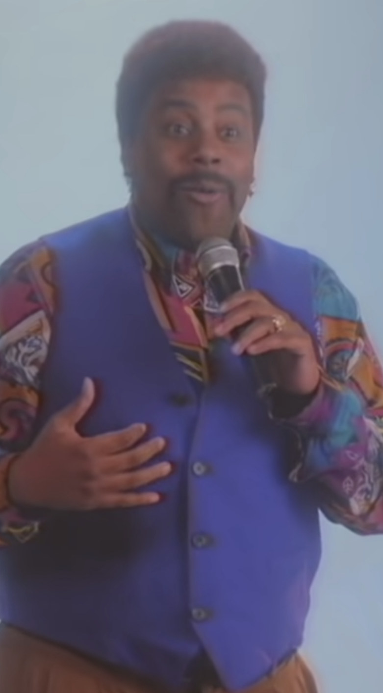 Thompson wearing a colorful shirt with a colorful vest over it