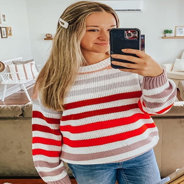 reviewer wearing the white, pink, red, and gray striped shirt