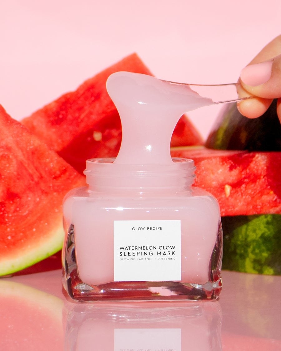 a model scoops out the gooey pink face mask from the jar