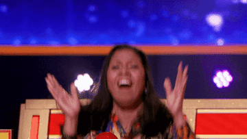 A game show contestant claps while jumping up and down, like they just won
