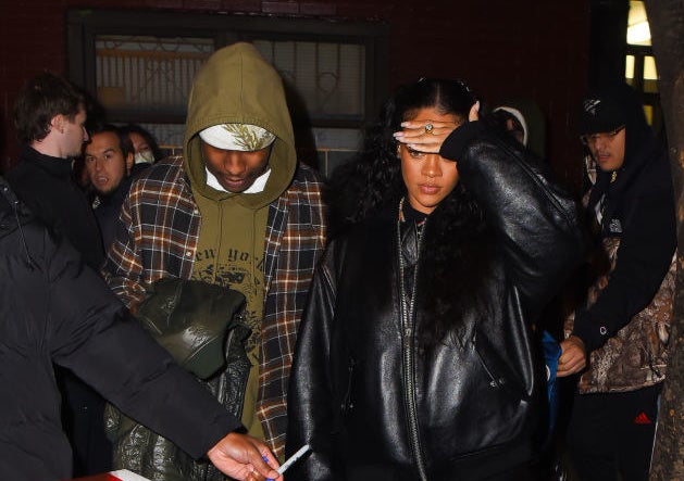 Rihanna shields her face from the flash of the camera