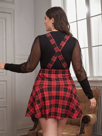 back of model wearing the black and red plaid pinafore dress