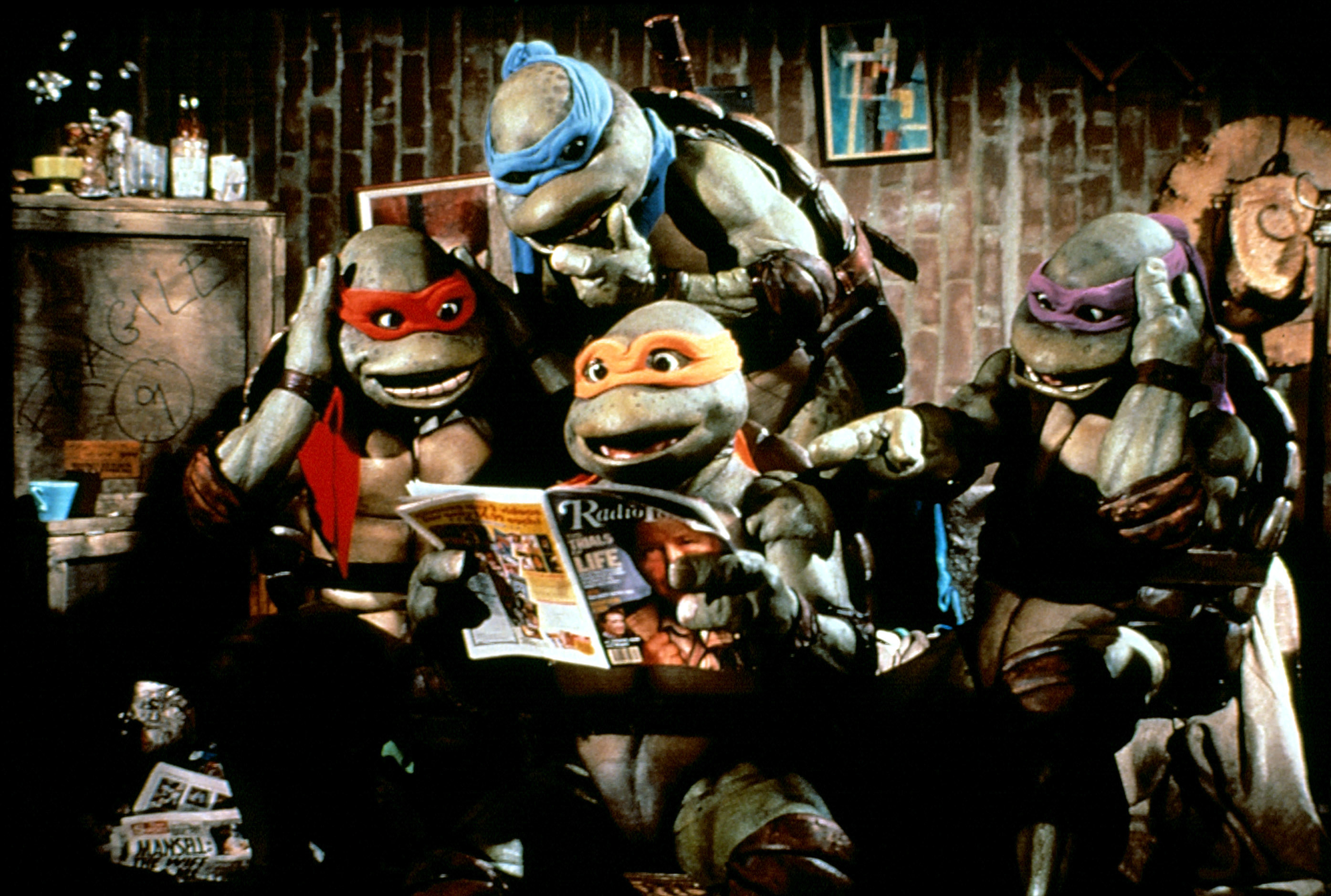 Michelangelo, Donatello, Raphael, and Leonardo looking at a magazine