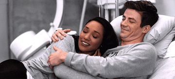 GIF man and woman cuddle in hospital bed