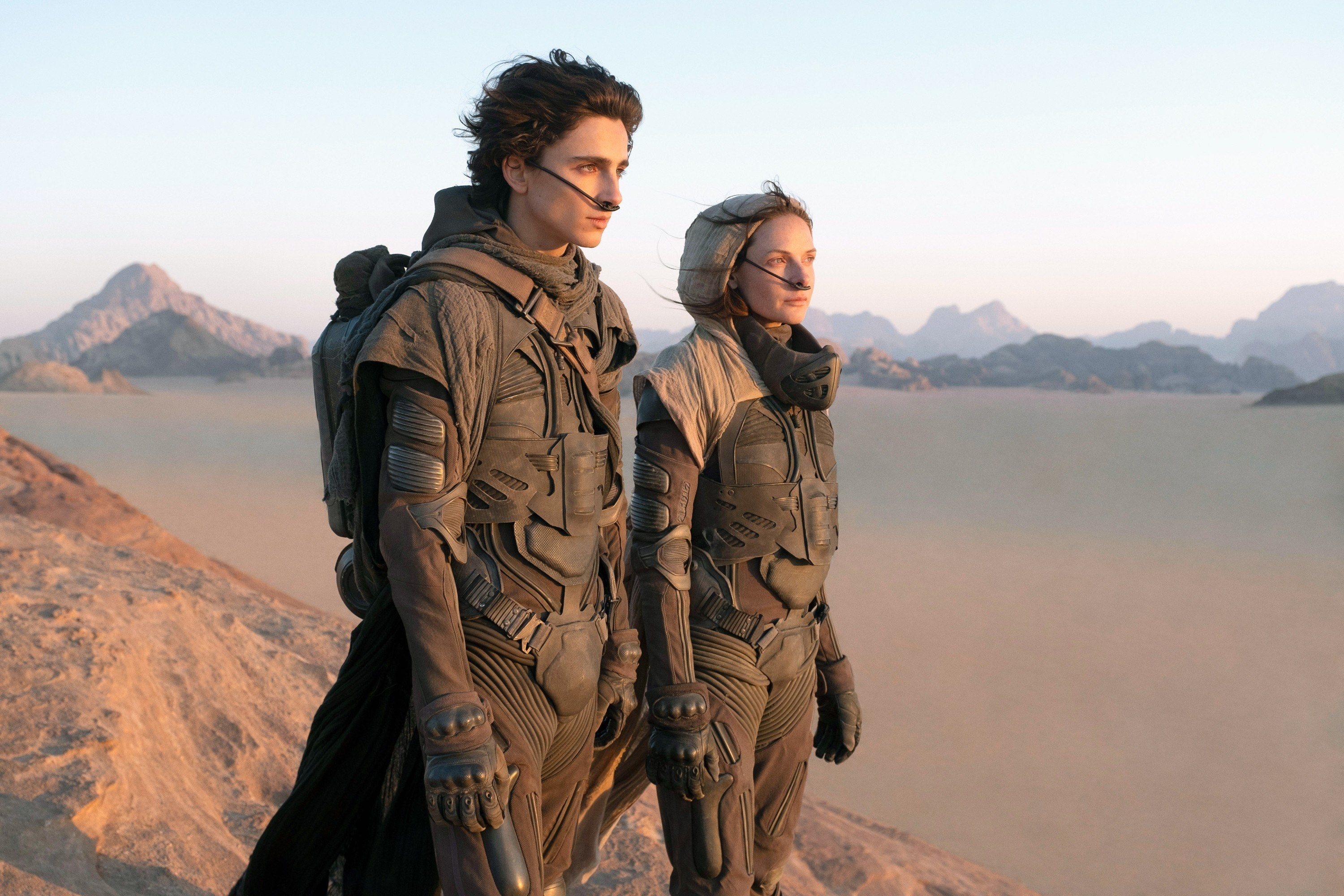 Timothee Chalamet and Rebecca Ferguson stand overlooking the desert
