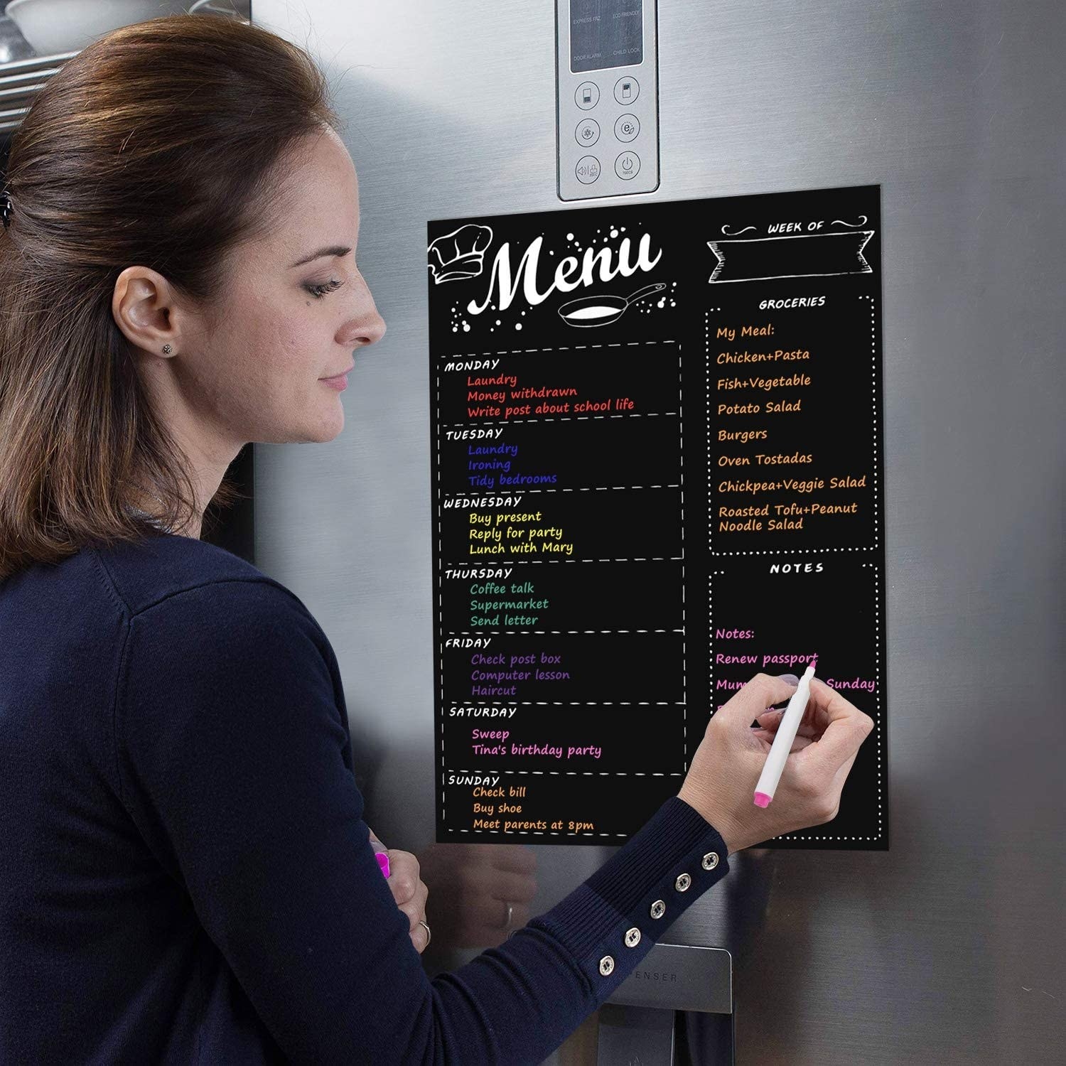 someone writing on the magnetic dry erase menu board
