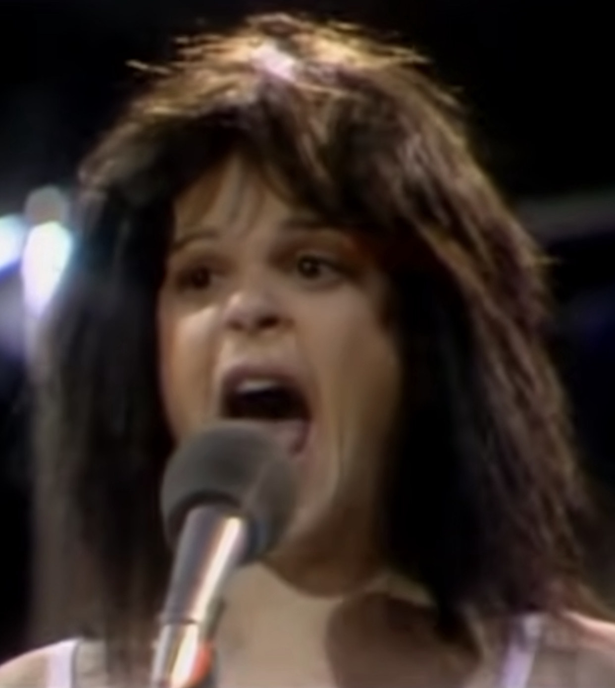 Radner wearing a Patti Smith-like hairdo and white tank top