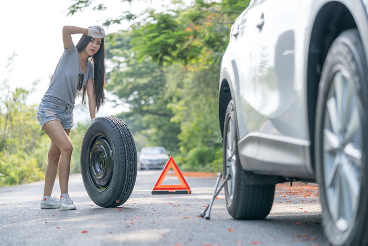 a woman changing a tire