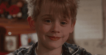 Macaulay as a child raising his eyebrows and smirking in the film Home Alone