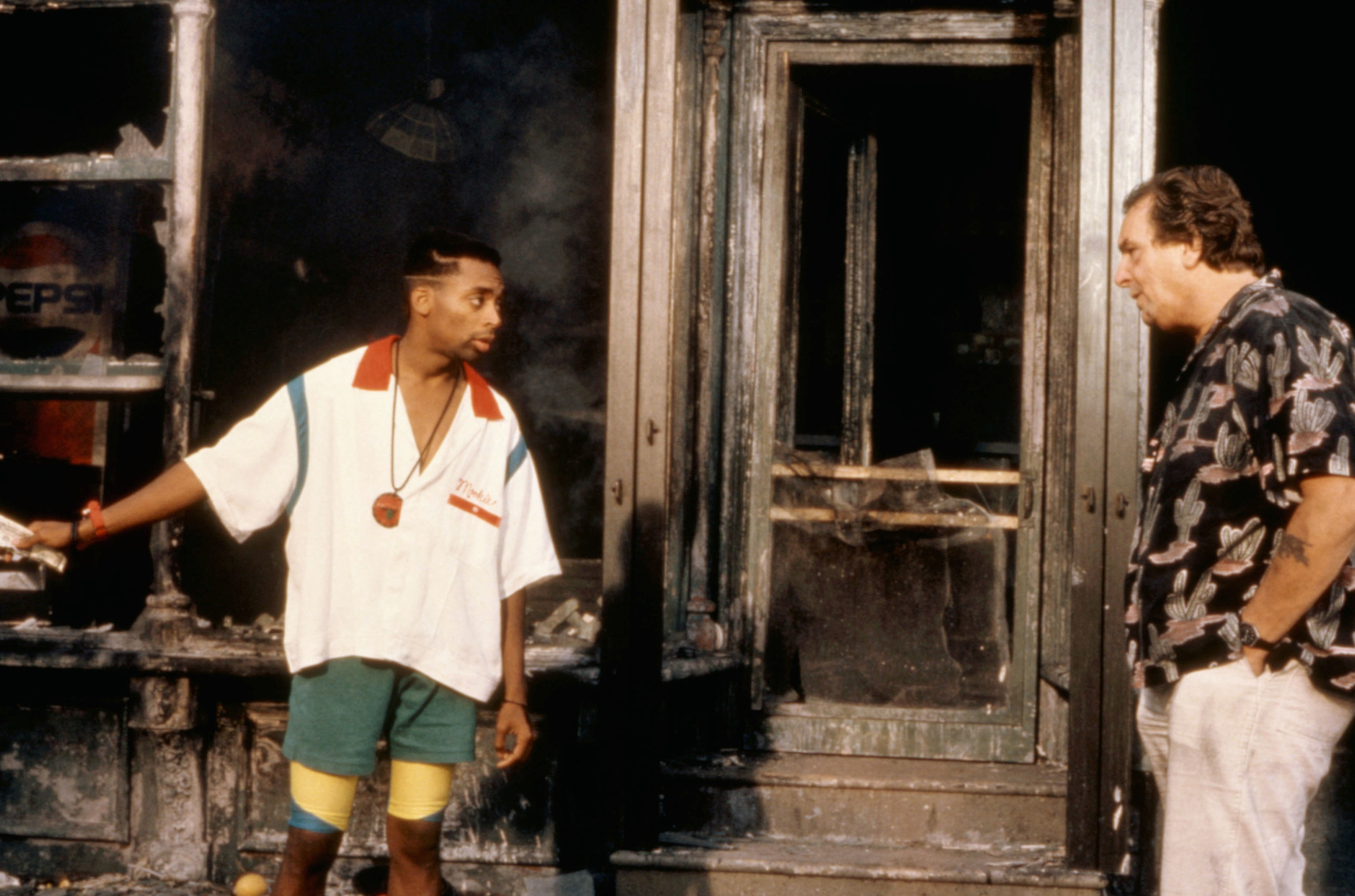 Spike Lee talks to Danny Aiello&#x27;s character out the front of the burned pizza shop