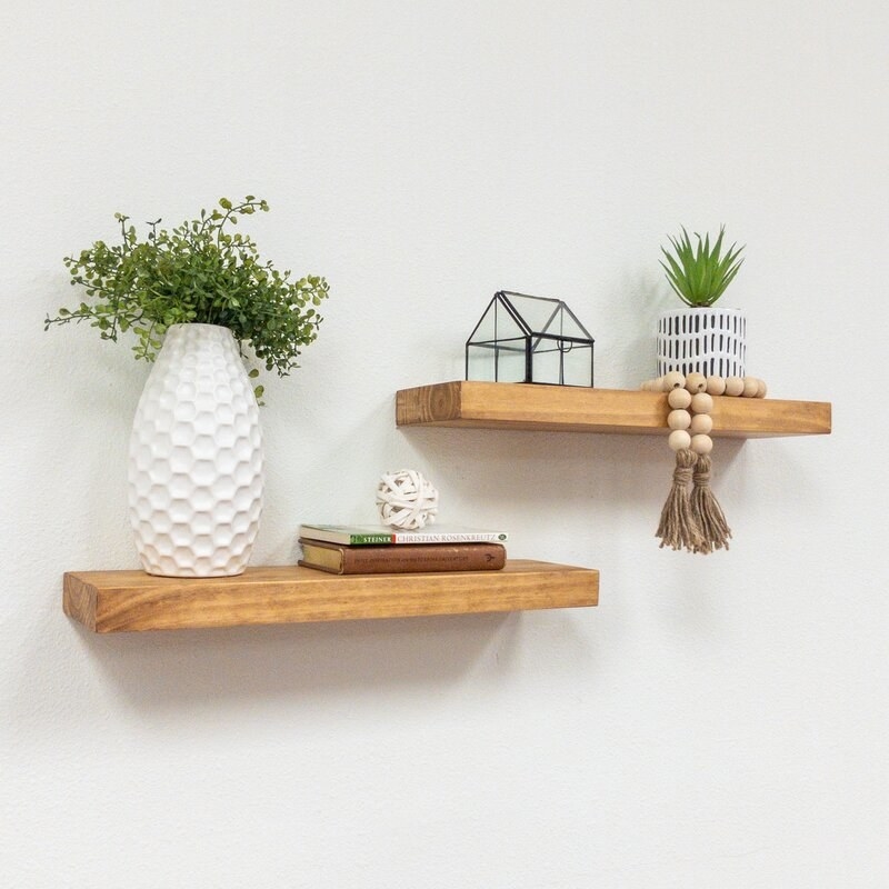 two wood floating shelves with decor on top
