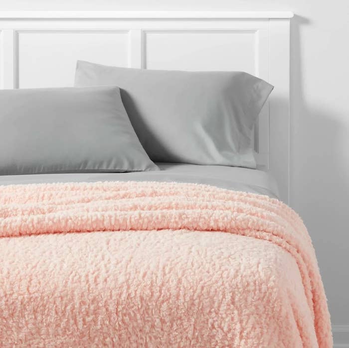 Pink sherpa blanket on a bed