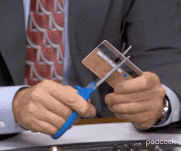 Michael Scott from The Office cutting up a credit card