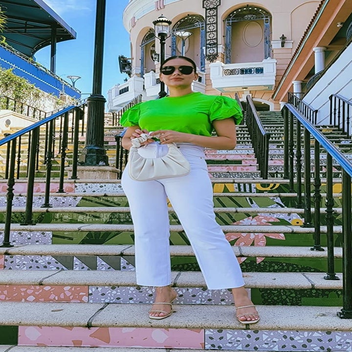 reviewer holding the cream colored bag