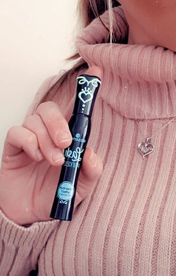 a reviewer holing the black mascara tube