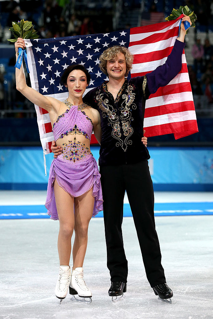 the duo holding up an American flag behind them after they won the gold
