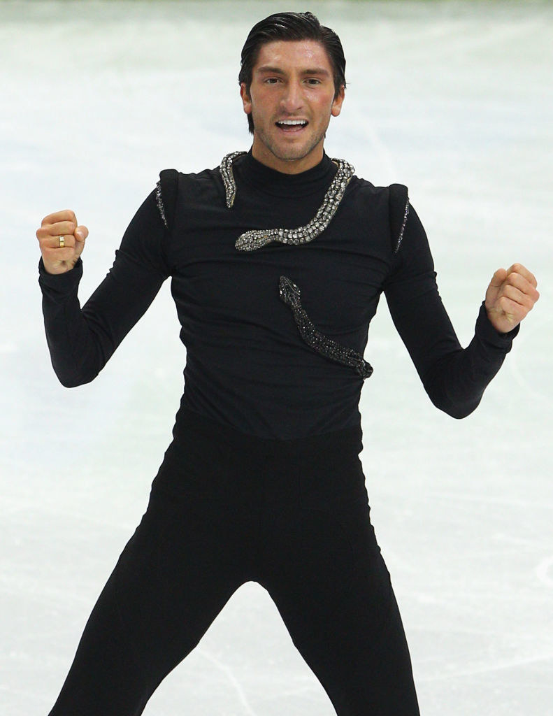 evan on the ice in all black with a jewel-encrusted snake around his neck