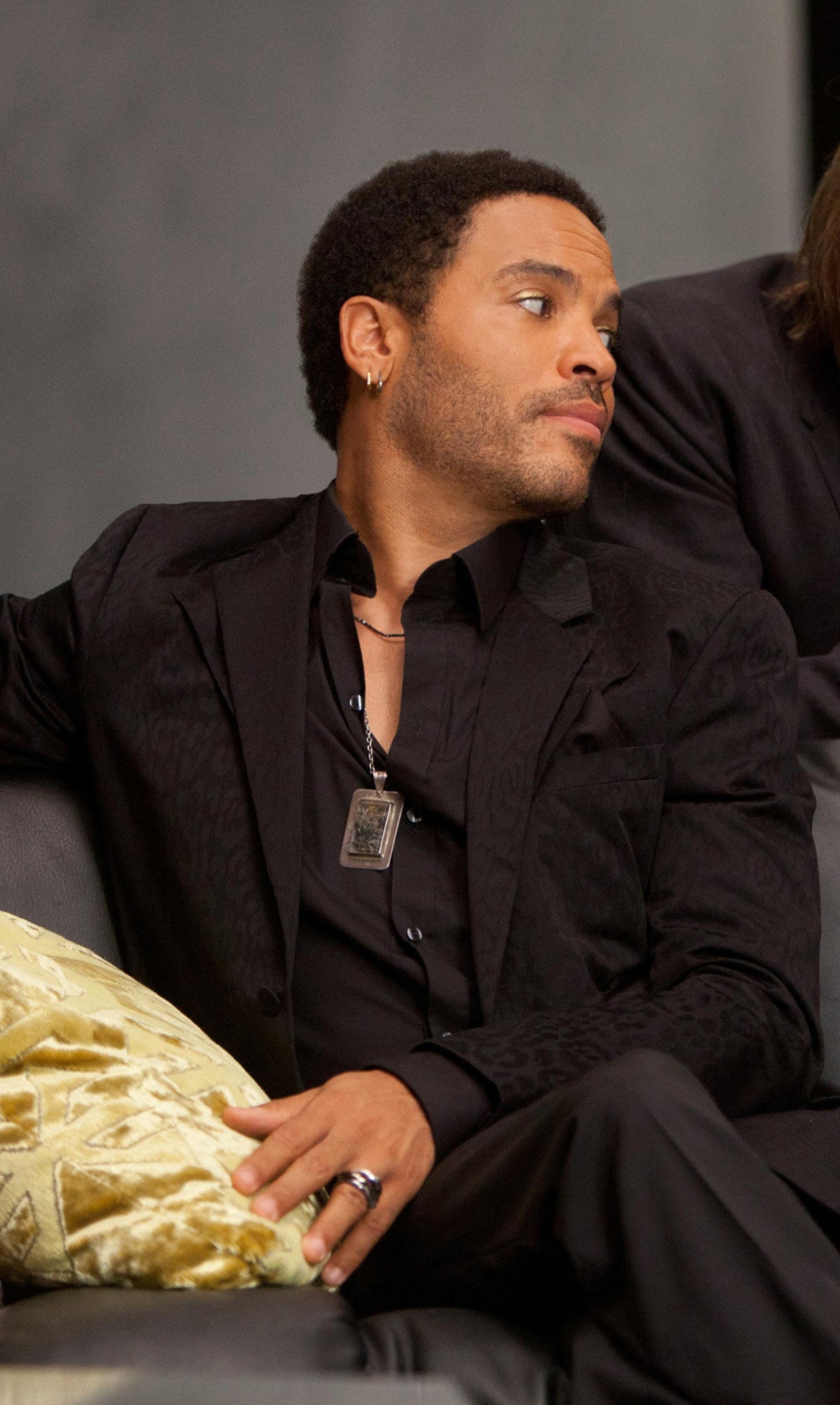 Cinna in a black suit with silver jewelry
