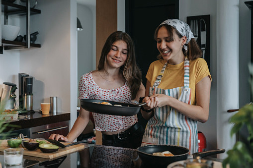 Teen girls cook breakfast together