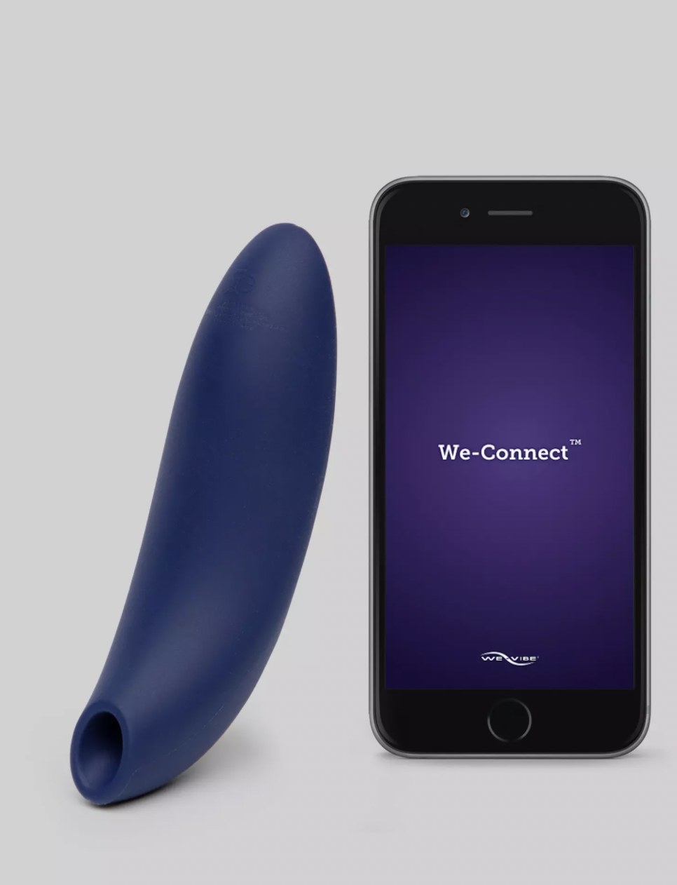 The clitoral vibrator next to smartphone displaying the app