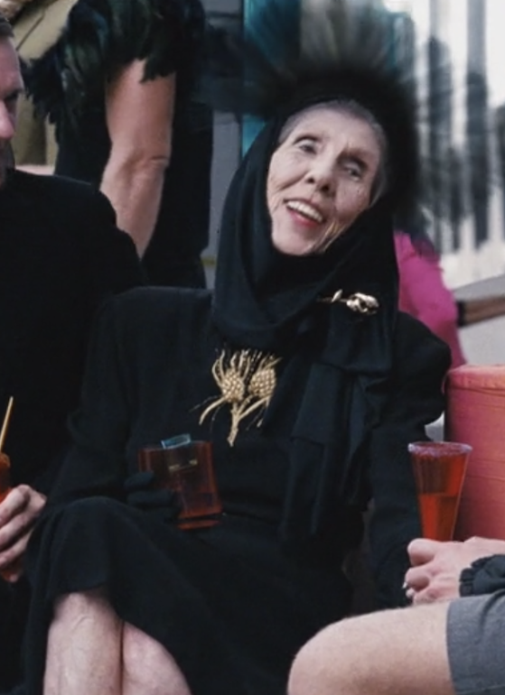 A Capitol woman wearing a black veil laughs with her friends