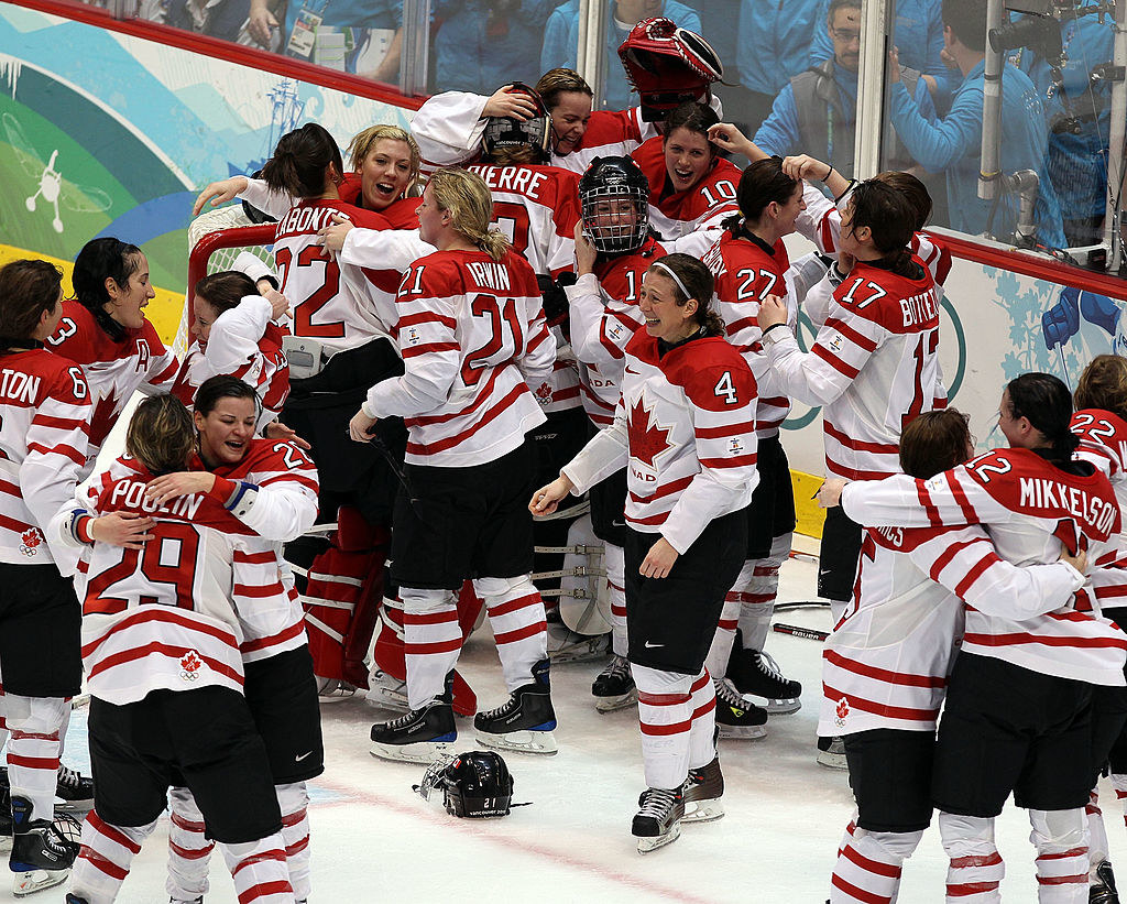 A hockey team in red and white jerseys cheering