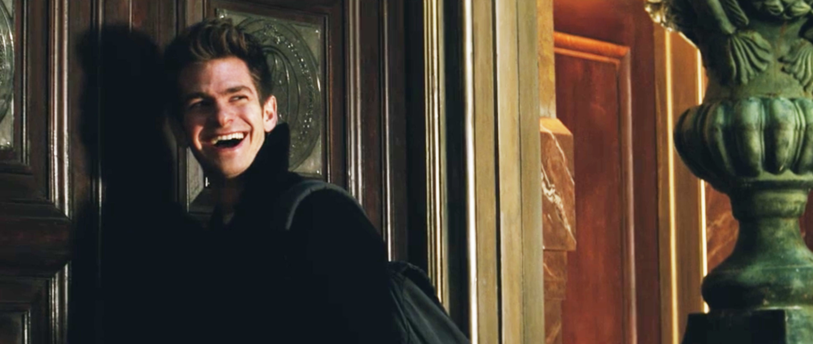 Andrew smiling as he stands in front of a door in a scene from Spider-Man