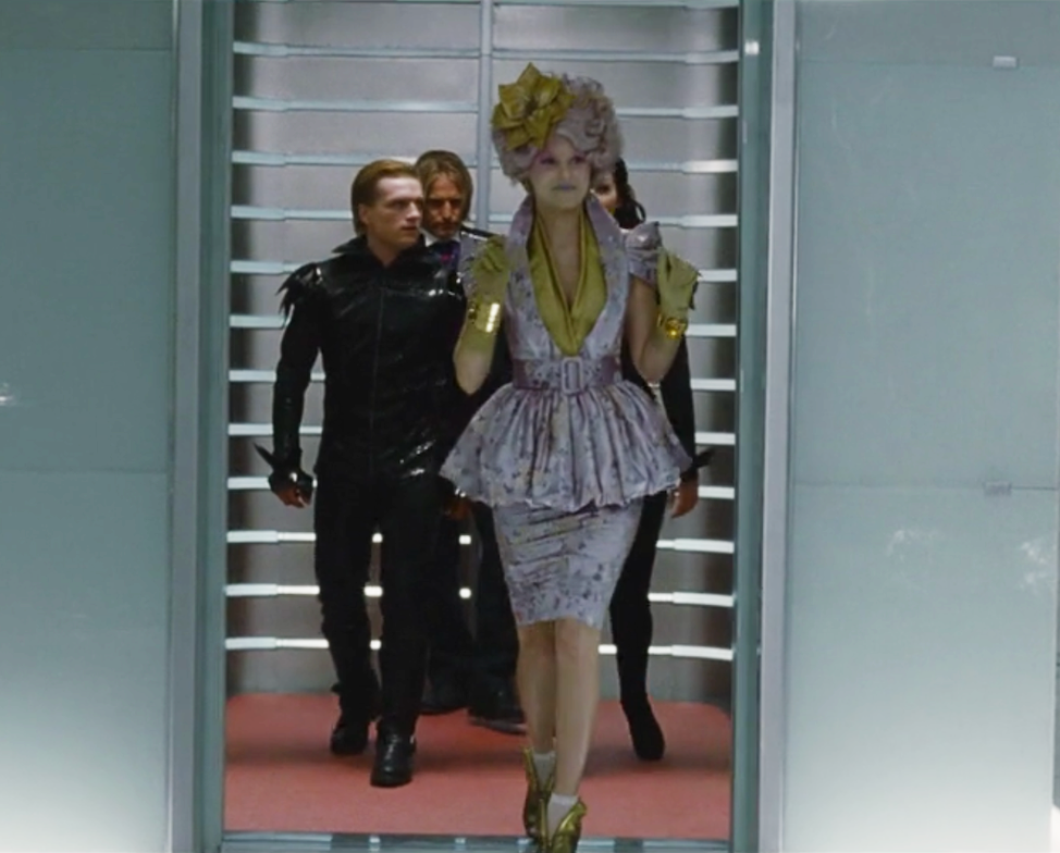 Effie steps out of the elevator with the tributes