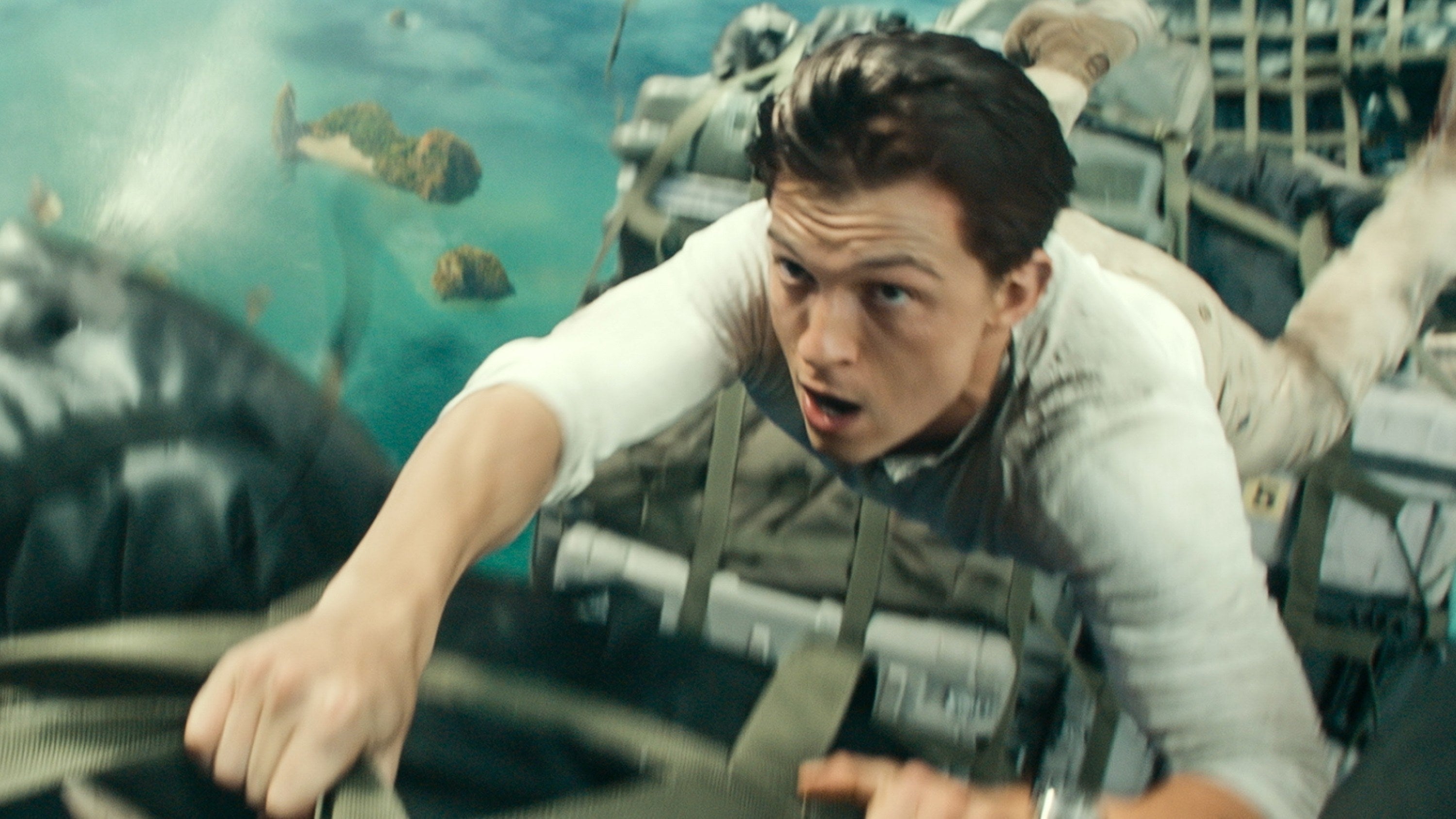 Tom holding onto a cargo plane in a scene from Uncharted