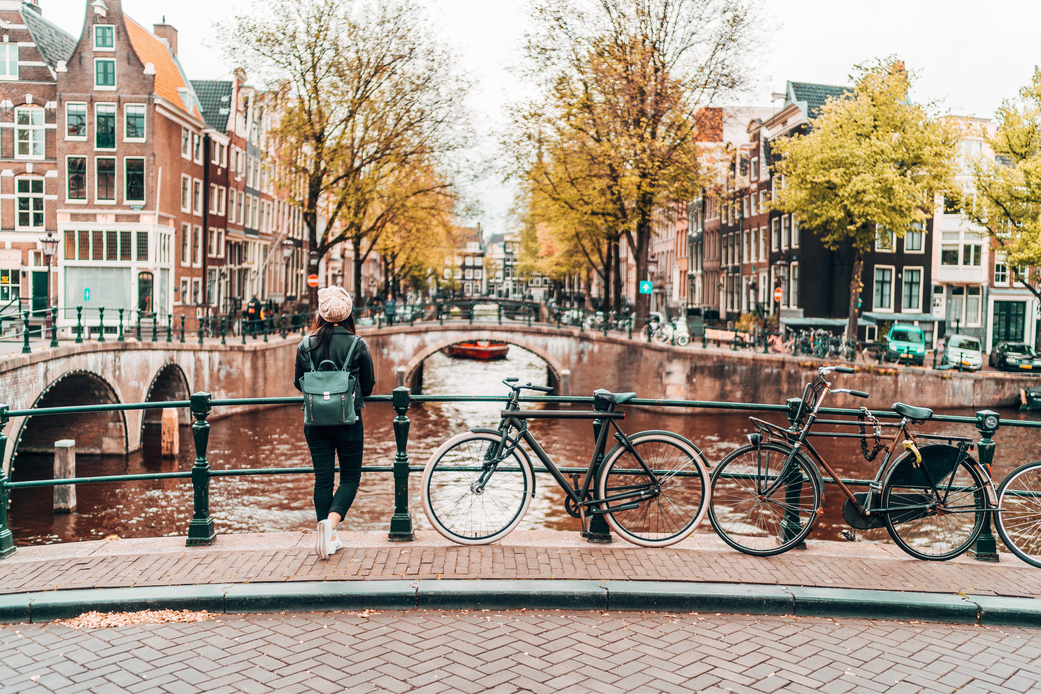 Woman Standing On Footbridge Over Canal In City