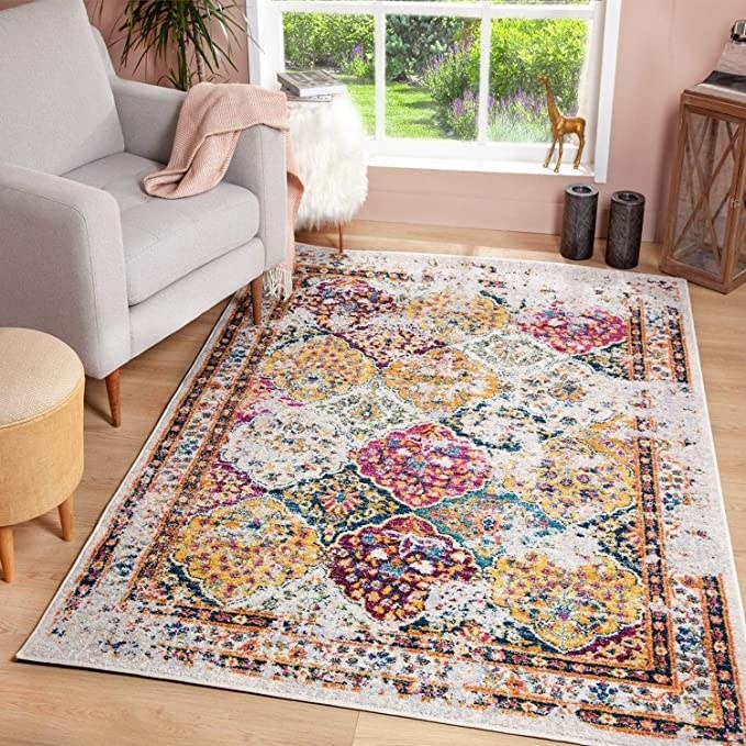 The printed area rug on top of hardwood floor in a room with a chair and candles