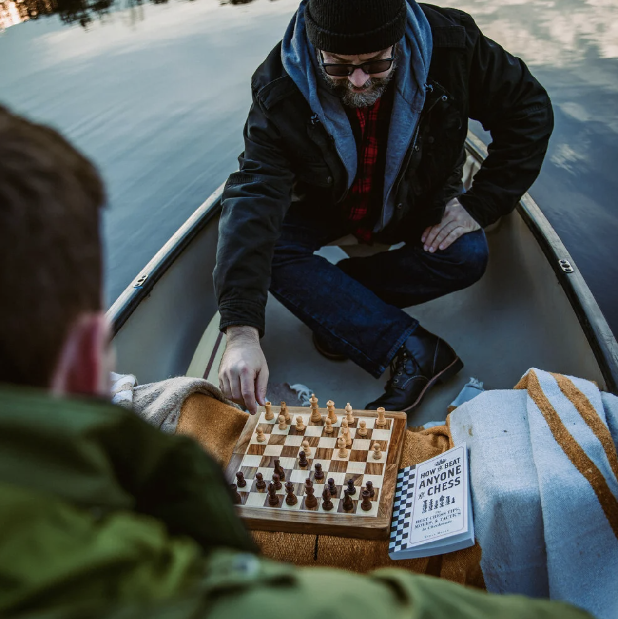 people playing with the chess set in a canoe