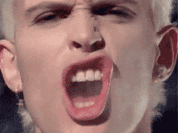 Billy Idol sneering with smoke in mouth