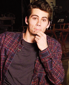 Dylan O&#x27; Brien winking whilst sitting in a chair in an interview