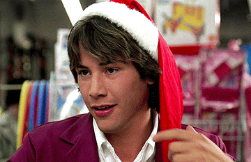 Keanu Reeves with santa hat on twirling the hat end in Babes in Toyland