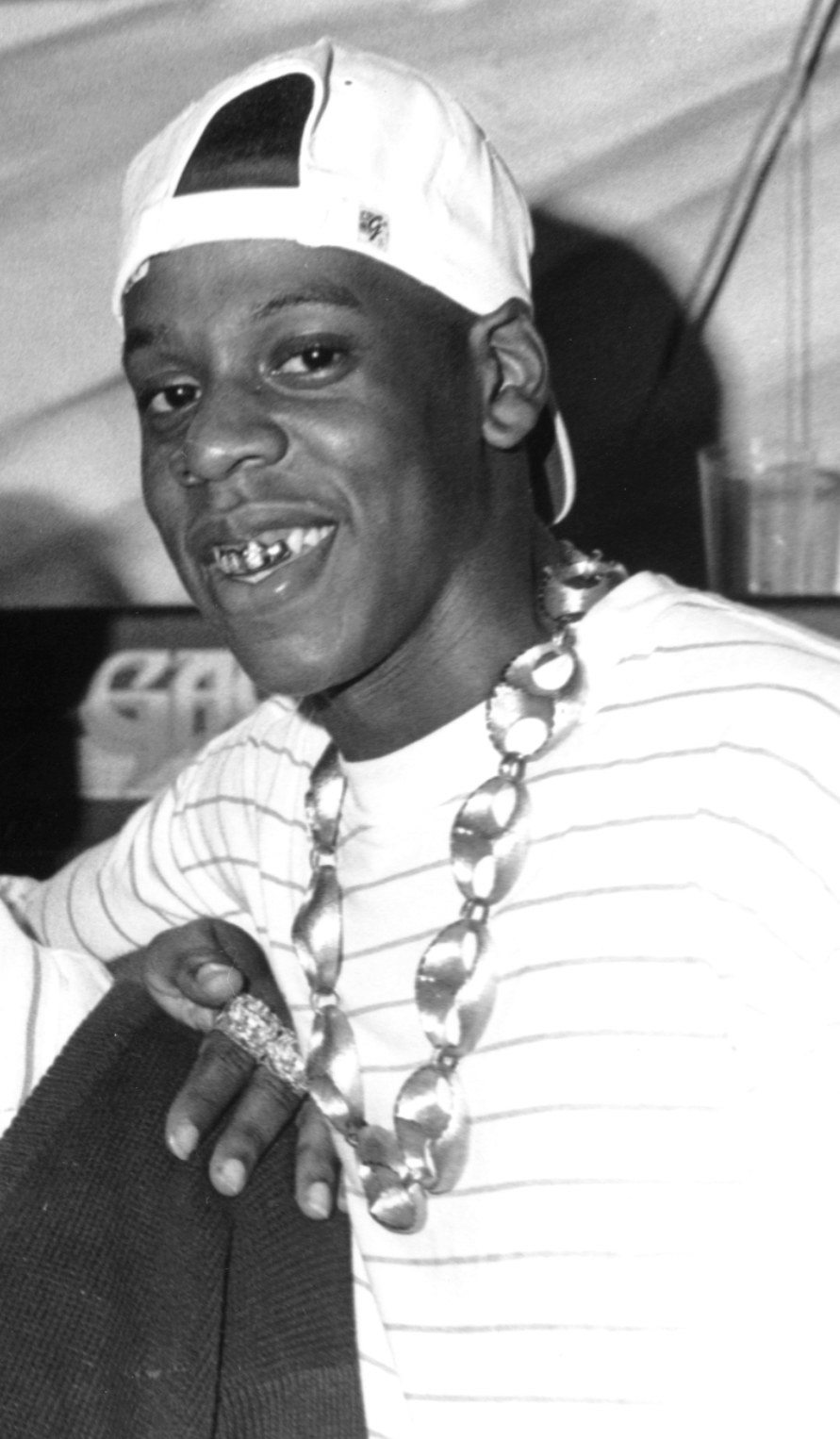 Jay-Z with gold teeth, backwards hat, and a chain