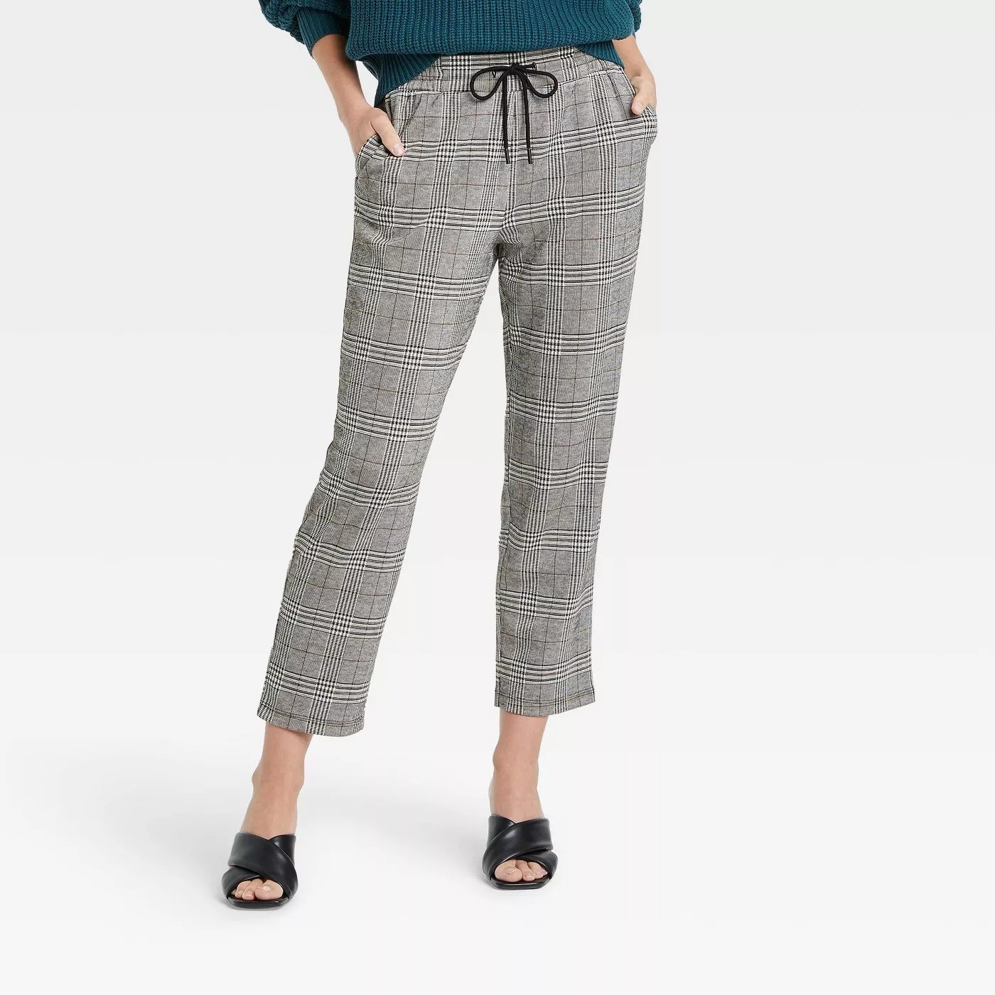 Model wearing gray plaid pants, stops above the ankle