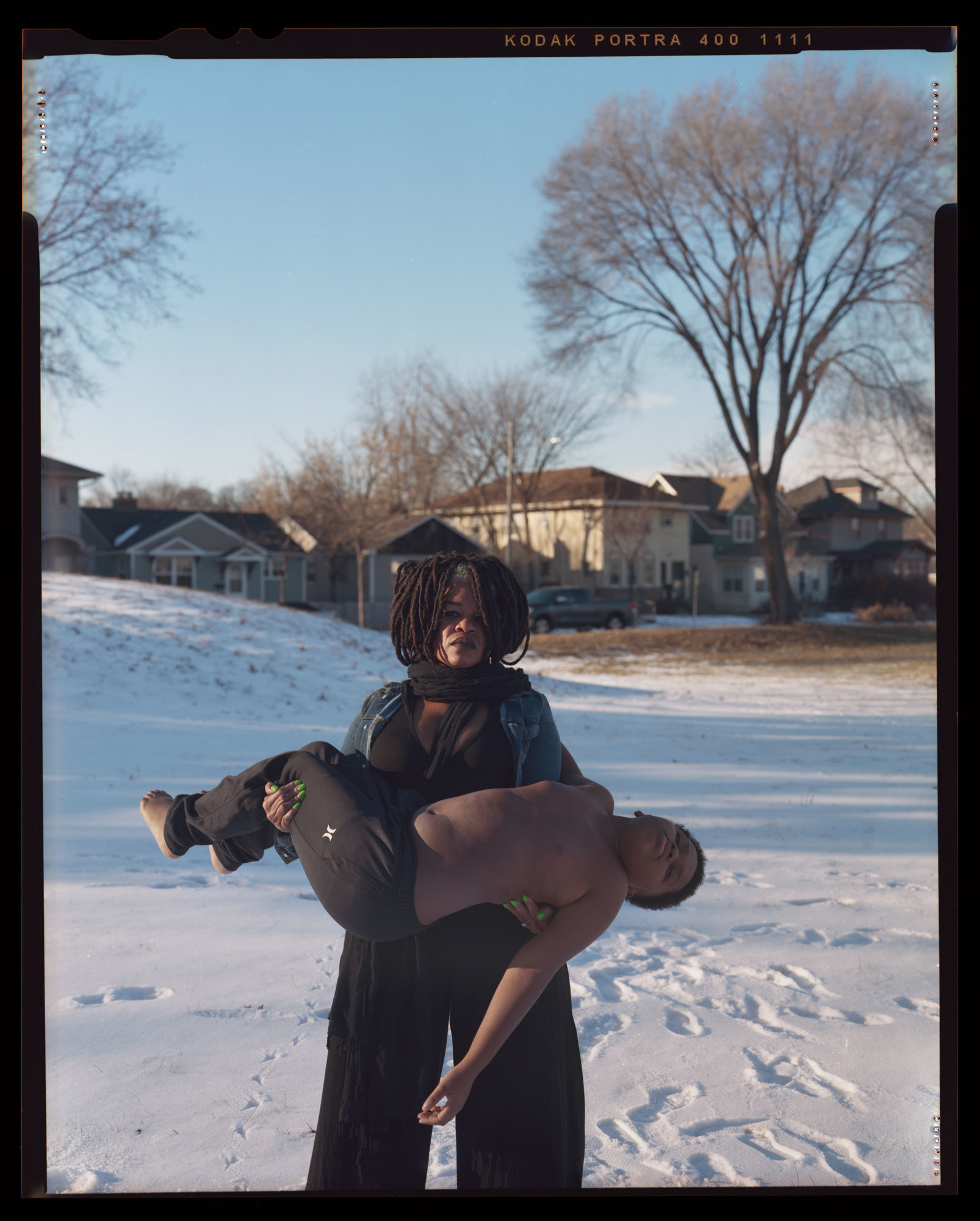 A young child is held in his mother&#x27;s arms on a snowy day