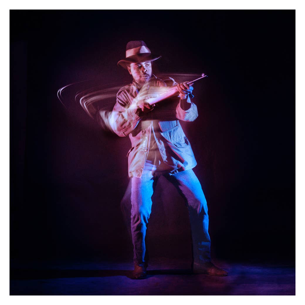 a man wearing cowboy get up with a rifle in slow motion