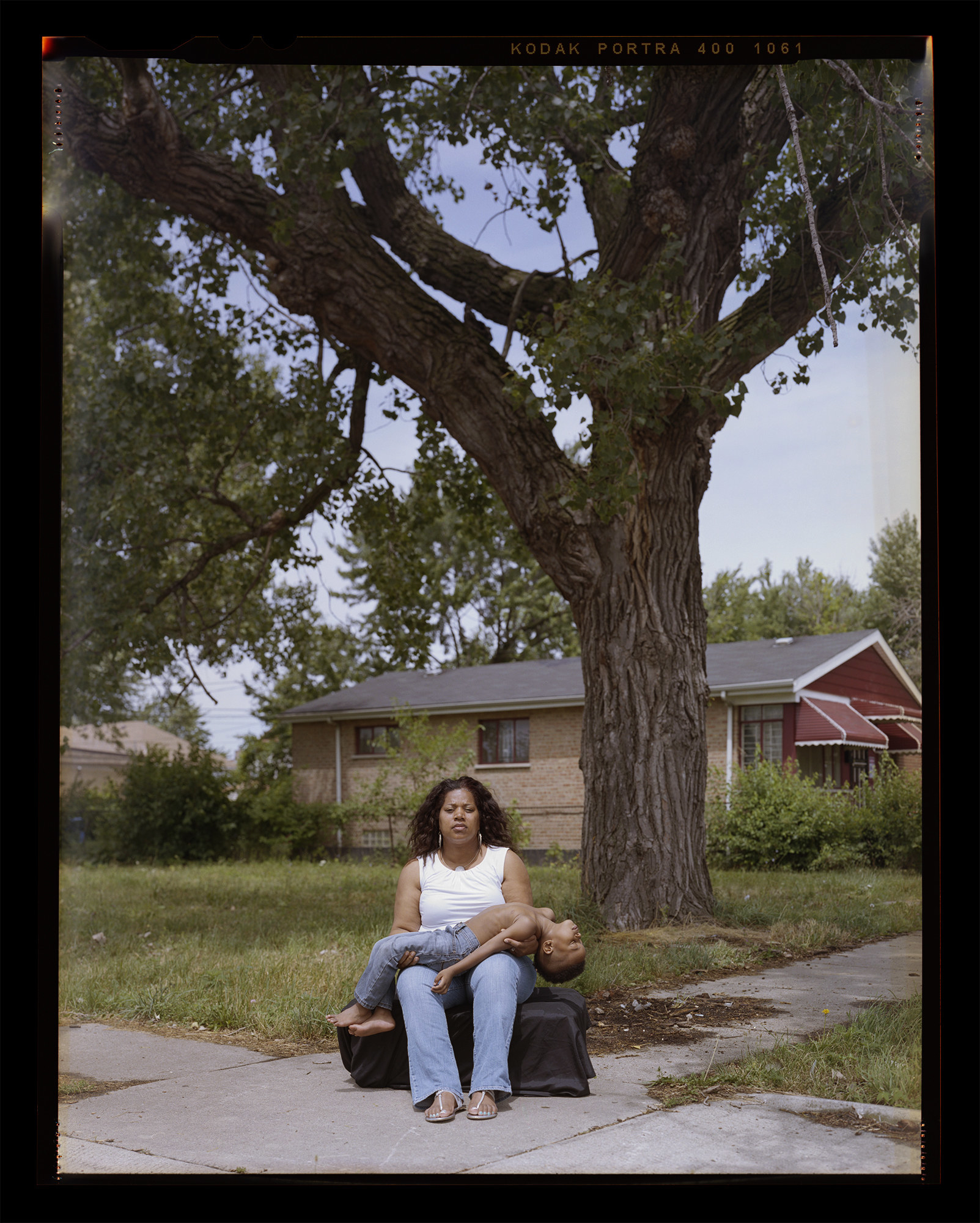 A woman sits with her young child lying in her arms